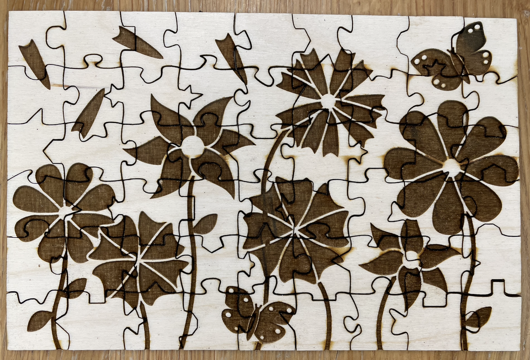 Top view of the 54 piece puzzle. It has high color contrast between the light tan wood and the dark brown etching.