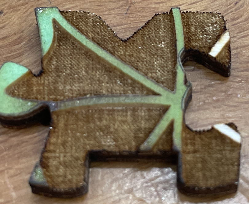 Close-up of puzzle piece with cross-hatching texture within the etching and along the cut edge.