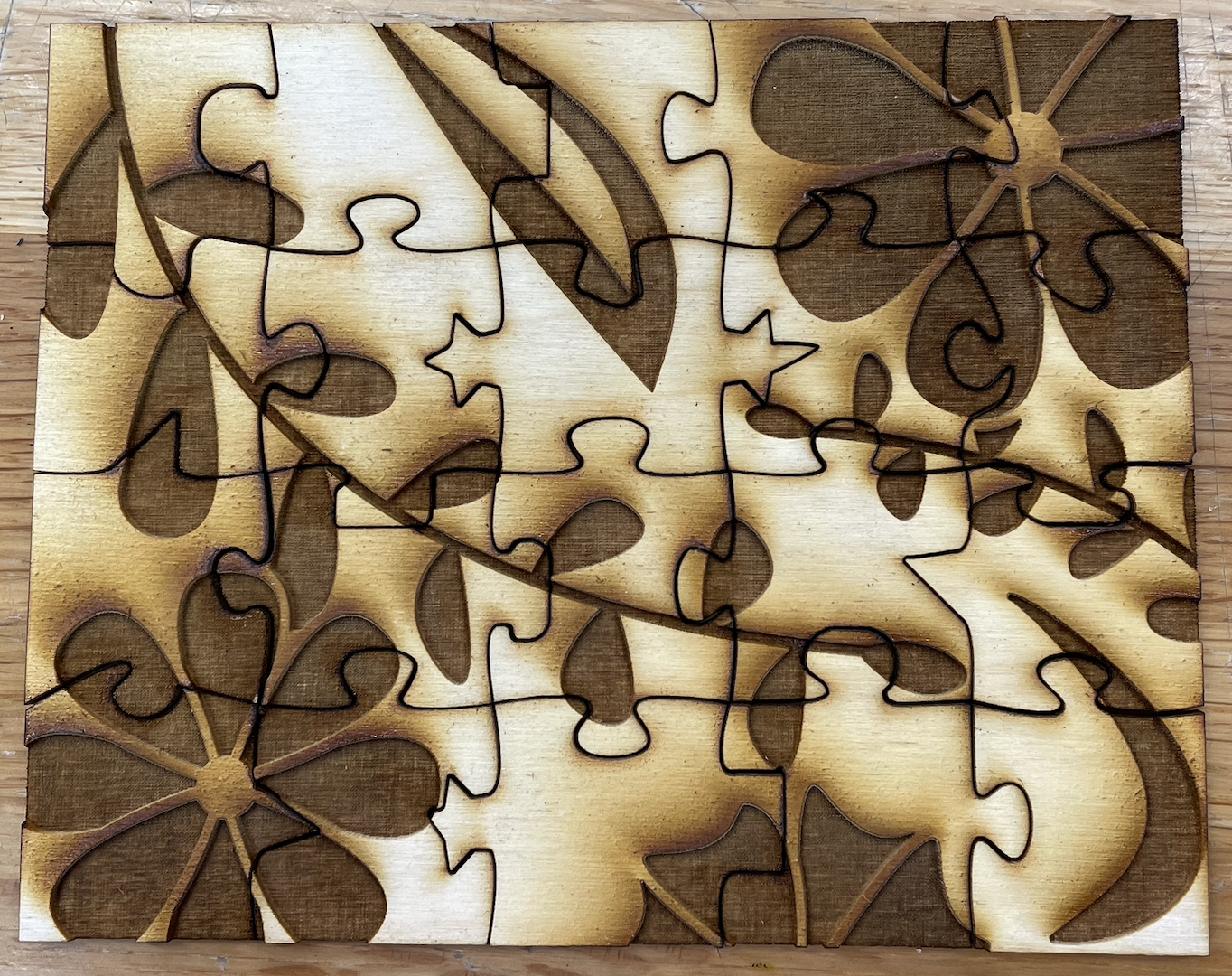 Top view of the twenty-piece laser cut tactile puzzle. It is a horizontal rectangle, being four pieces tall by five pieces wide.